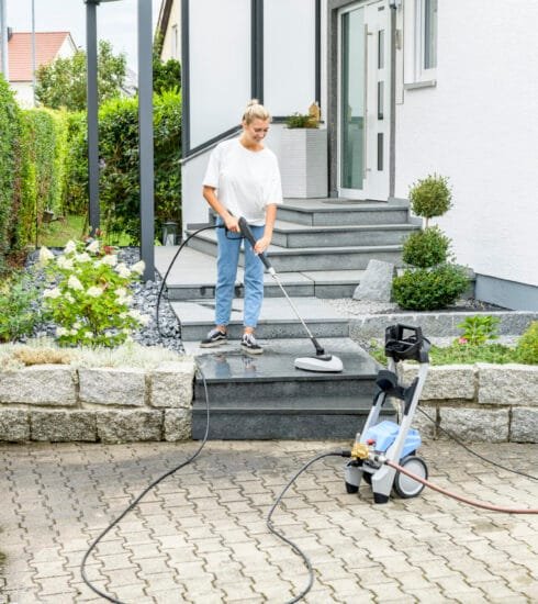 Kränzle Quickly Frau mit Reinigungsgerät säubert eine Außentreppe.