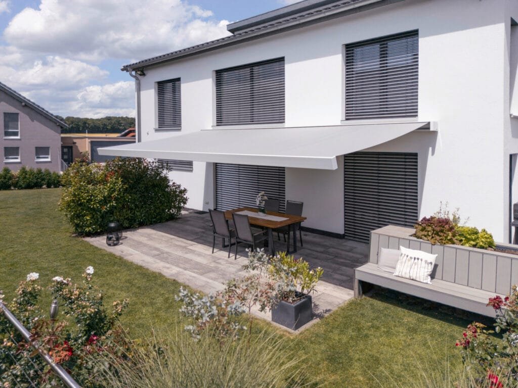 Außenansicht eine Hauses mit Sonnenschutz über der Terrasse.