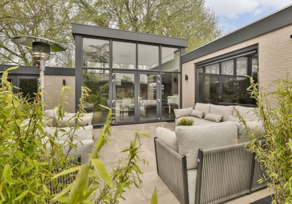 Ein Outdoorbereich mit Sofas, Bäumen und Haus mit Winkel