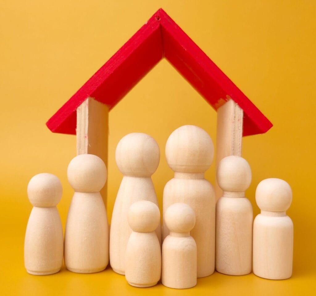 Holzfiguren und Holzhaus mit rotem Dach