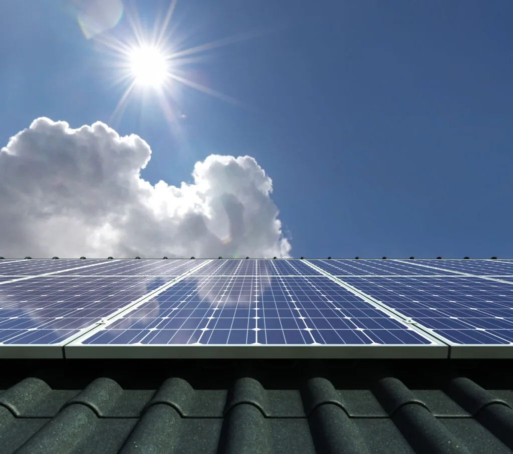 Photovoltaikmodule auf einem Dach werden von der Sonne beschienen