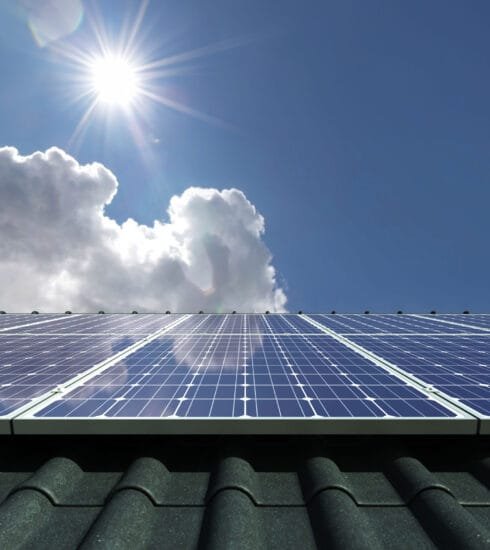 Photovoltaikmodule auf einem Dach werden von der Sonne beschienen