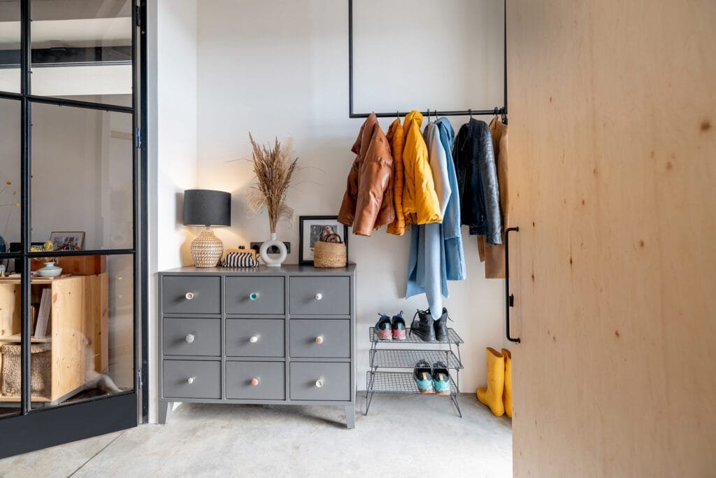 Eine Eingangsdiele mit Garderobenstange für Jacken, Schuhregal und Kommode
