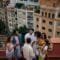 Eine Freundesgruppe steht auf dem Balkon und unterhält sich. Im Hintergrund ist der Ausblick auf eine Stadt sichtbar. Foto: CarlosBarquero/www.elements.envato.com