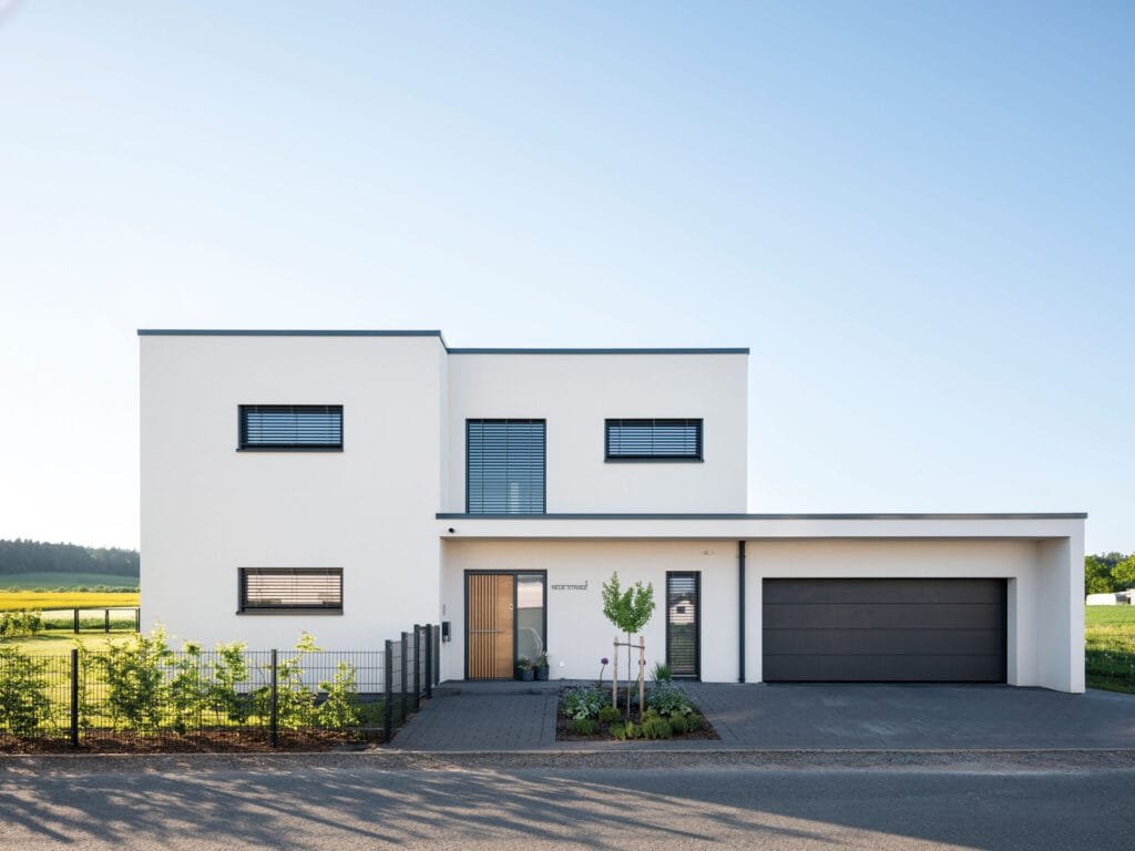 Die Straßenseite der zweigeschossigen individuellen Kundenhausplanung mit Flachdach  von Fingerhaus.