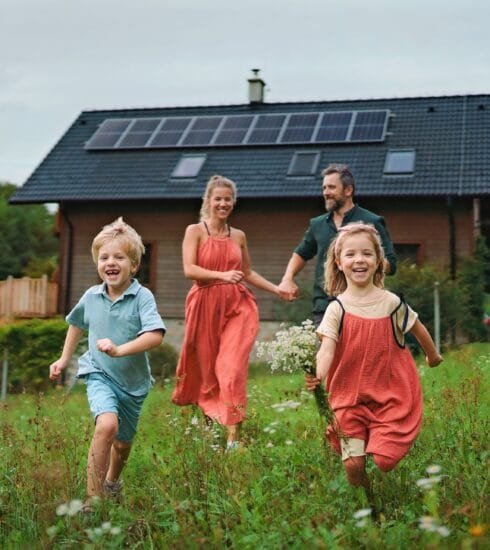 Familie vor Haus im Grünen