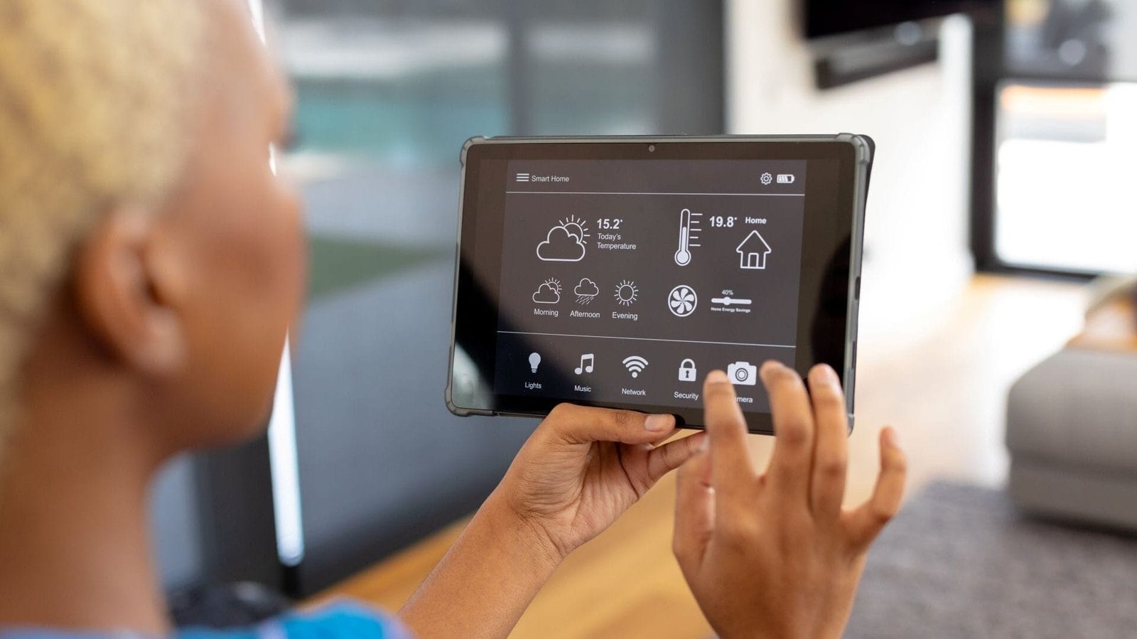 Eine Frau kontrolliert auf dem tablet verschiedene Smarthome-Komponenten.