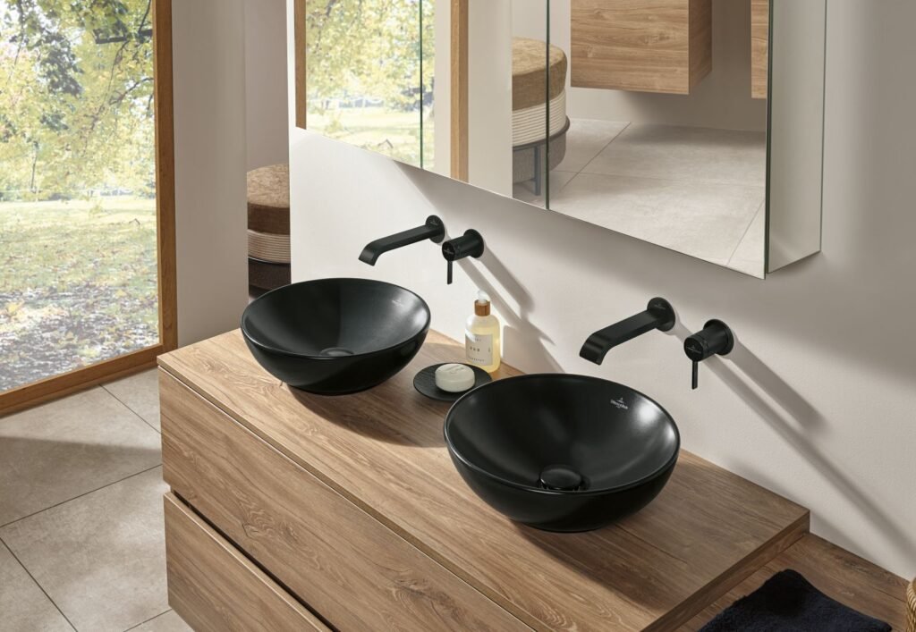 Waschtisch im Badezimmer aus Holz und mit schwarzen Waschbecken