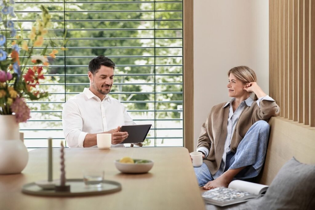 Frau und Mann mit Tablet sitzen am Esstisch