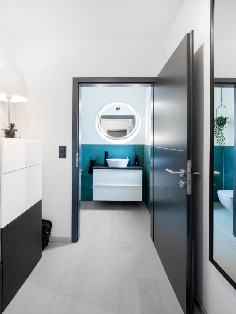 Flur mit Gäste WC, schwarzer Tür und hellem Boden