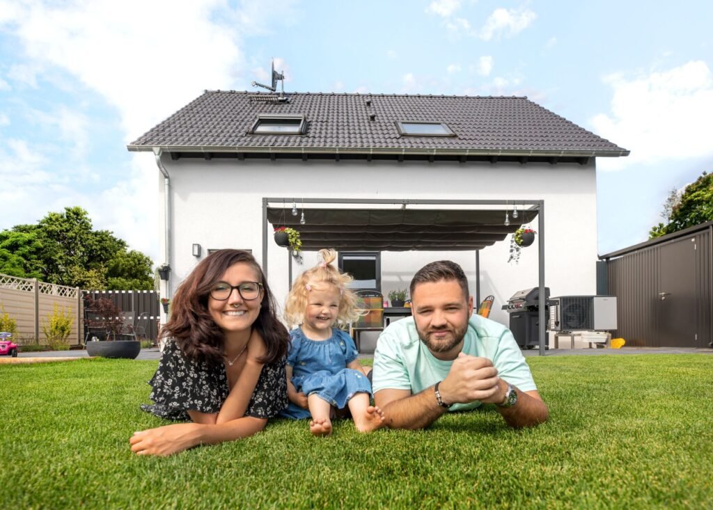 Fingerhut Haus Filino Haus von außen mit Baufamilie auf der Wiese