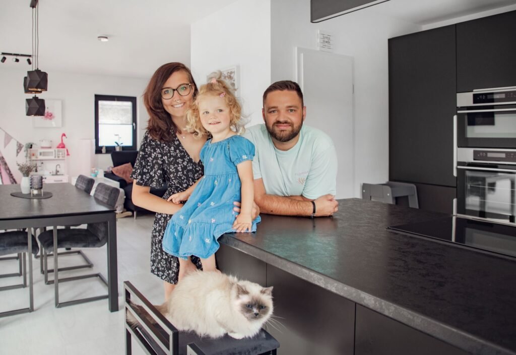 Mann und Frau mit kleinem Mädchen in der schwarzen Küche