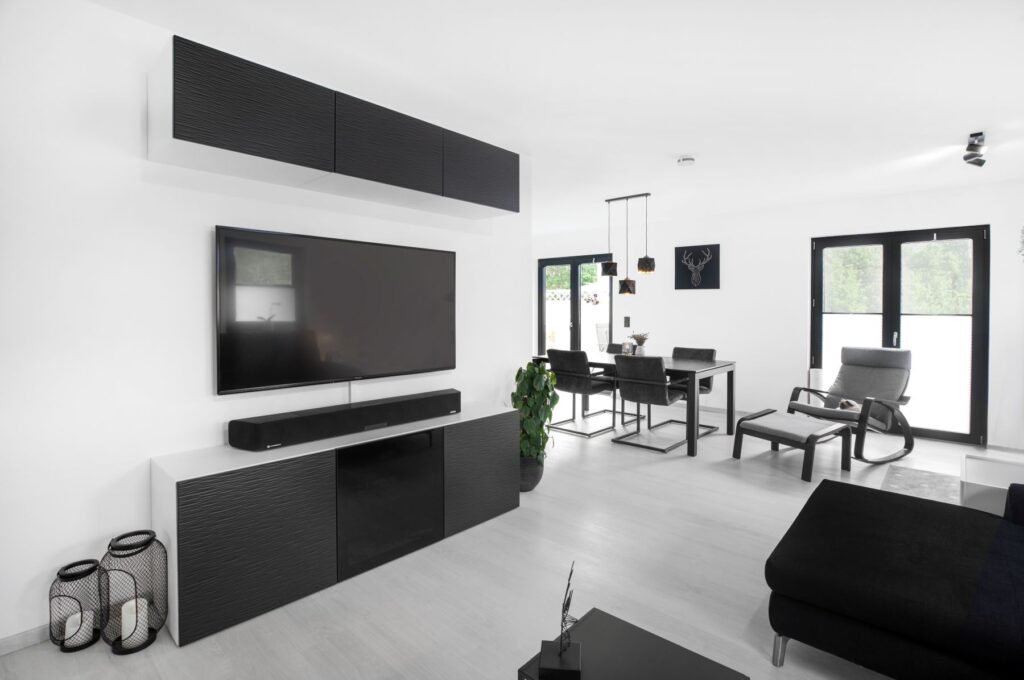 Wohnzimmer mit weißen Wänden und schwarzen Möbeln und Fensterrahmen