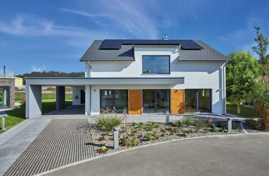 Musterhaus Günzburg Fertighaus Weiss Haus von außen mit Carport und Steingarten