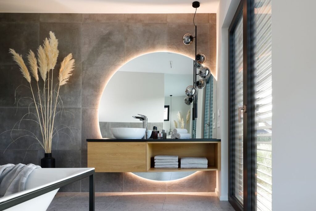 Schwörer Haus Kundenhaus Mette Nico Berlin Badezimmer mit grauen Fliesen und rundem Spiegel