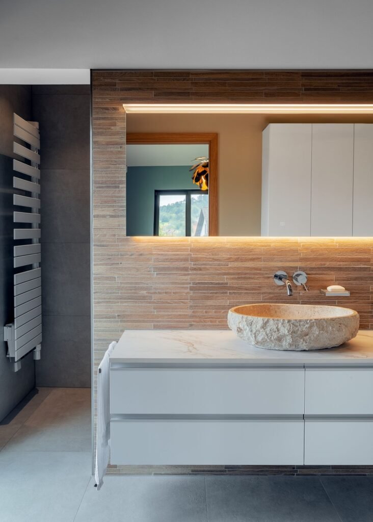 Weberhaus individuelles Architektenhaus Badezimmer mit Waschbecken aus Naturstein und Holzwand