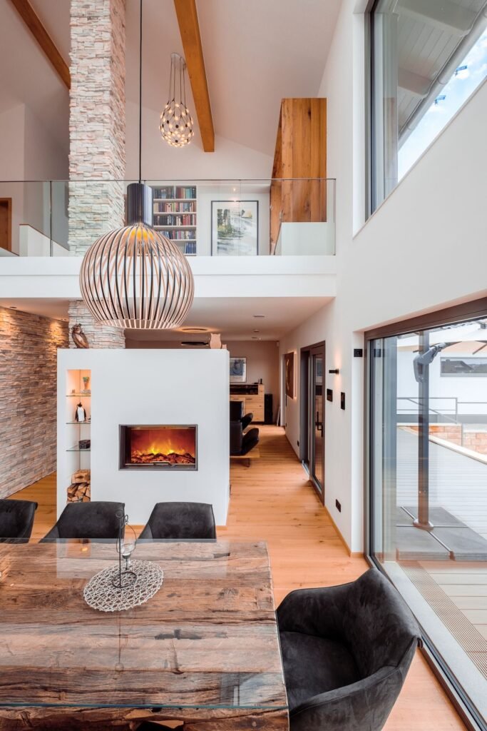 Weberhaus individuelles Architektenhaus offener Essbereich mit Luftraum und Kamin, Blick auf das Obergeschoss