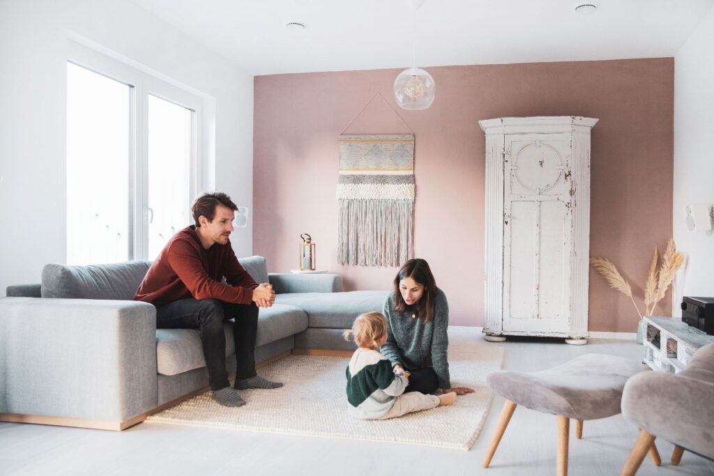 Die Baufamilie des Fingerhut Haus Vinaro mit Kind sitzt im Wohnzimmer zusammen