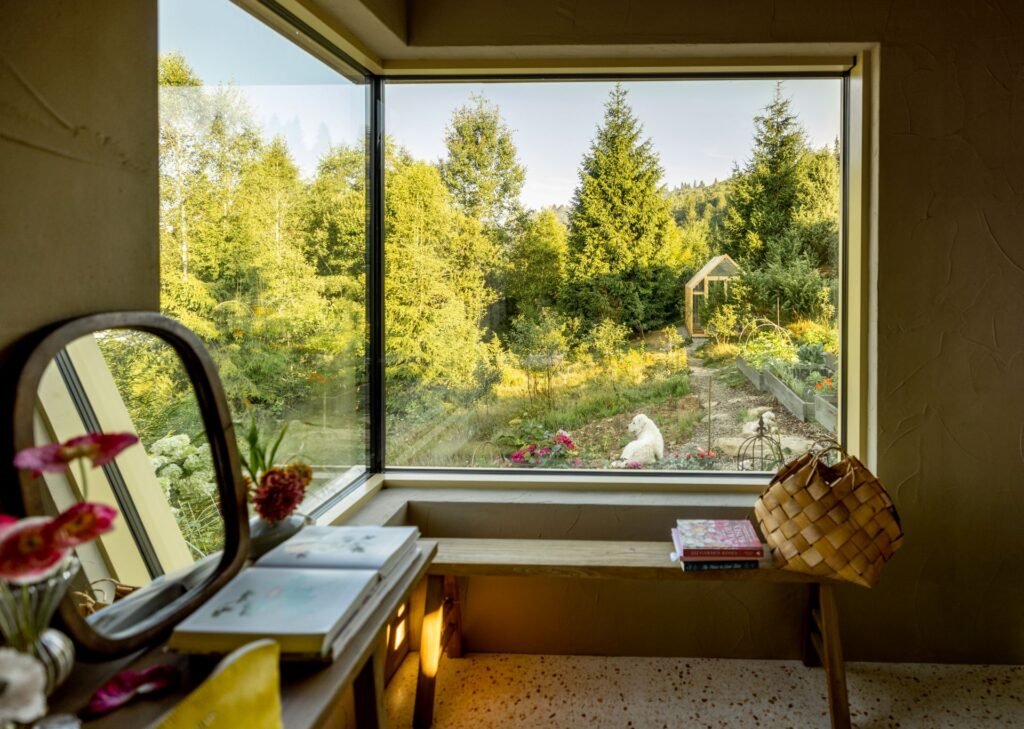Aus einem Schlafzimmer bietet sich über eine großflächige Übereckverglasung ein malerischer Ausblick in einen Garten. Foto: RossHelen/www.elements.envato.com