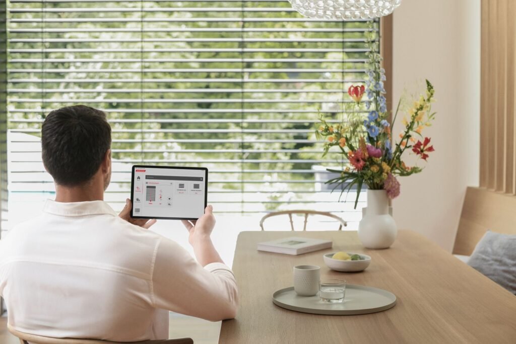 warema_Esszimmer mit Fenster und Sonnenschutz und Mann mit Tablet