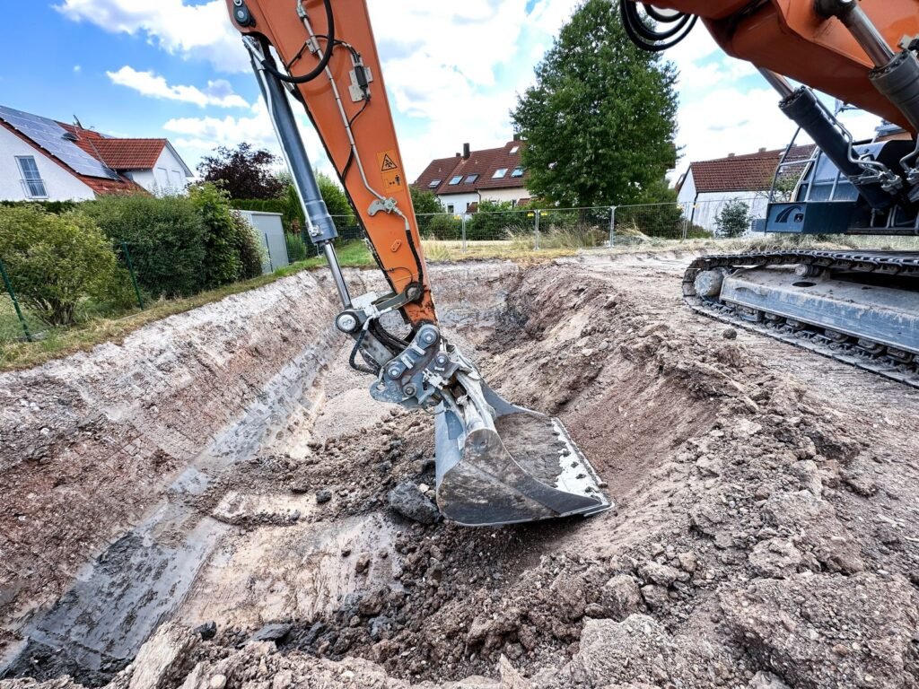 Erdarbeiten ausheben einer Baugrube mit dem Bagger Glatthaar Keller
