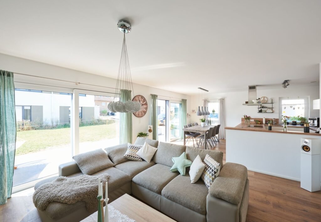 großer offener Wohn und Essbereich mit beigefarbener Couch und Esstisch