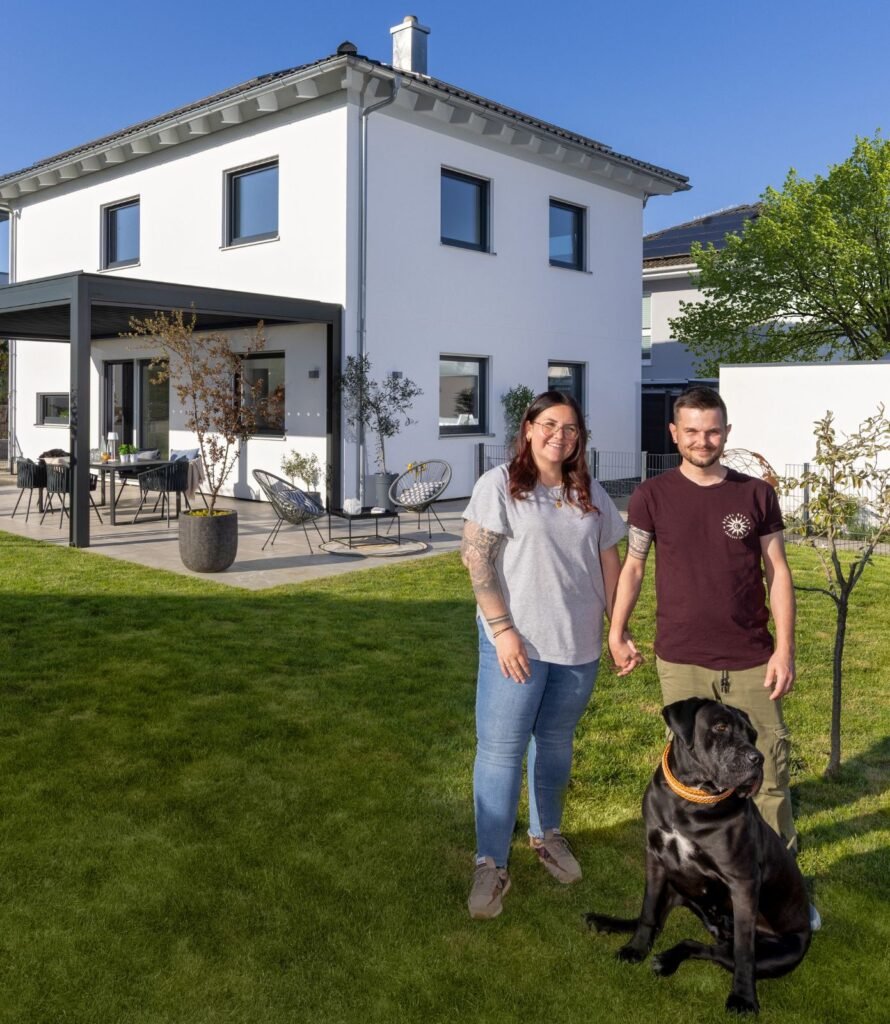 Paar vor dem Haus mit Hund