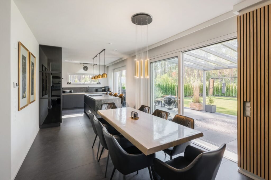 Weberhaus Graling Wohnzimmer und Küche mit schwarzen Möblen und goldenen Details