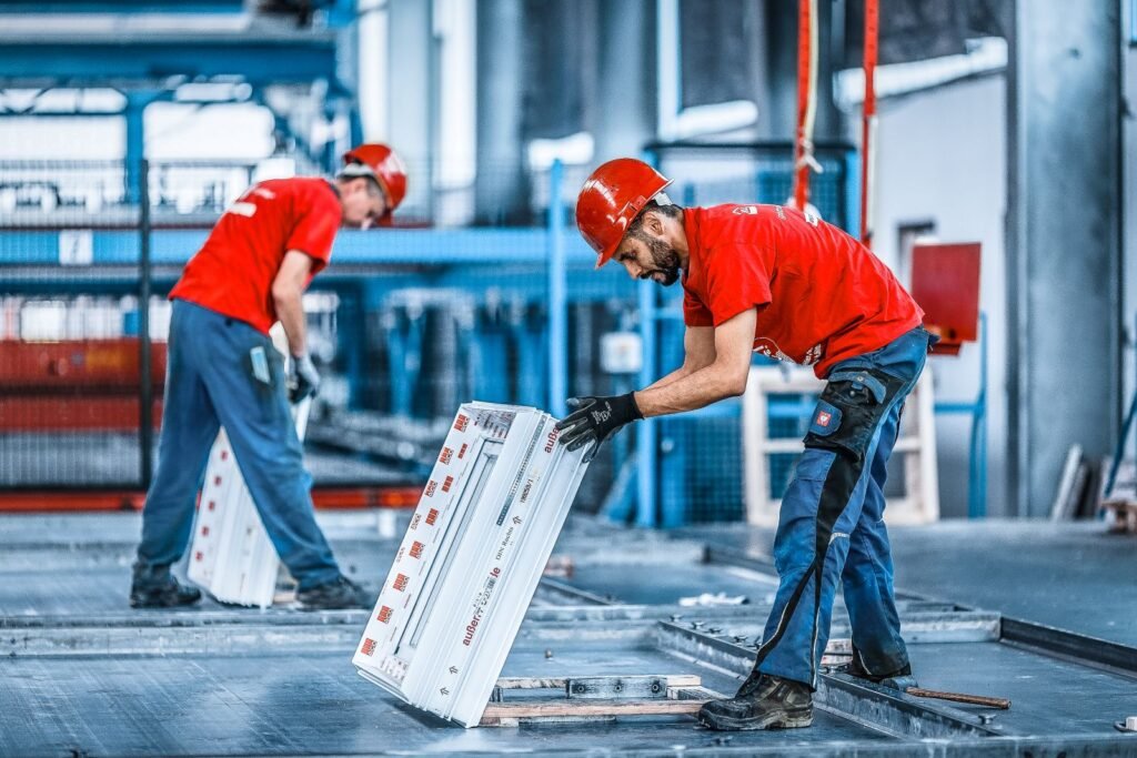 Zwei Arbeiter beim Einlegen von Einbauteilen eines Kellers im Werk