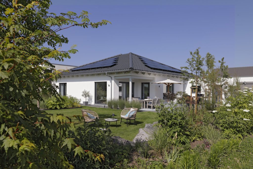 Der Walmdachbungalow von Familie Jacoby mit umliegendem Garten. 