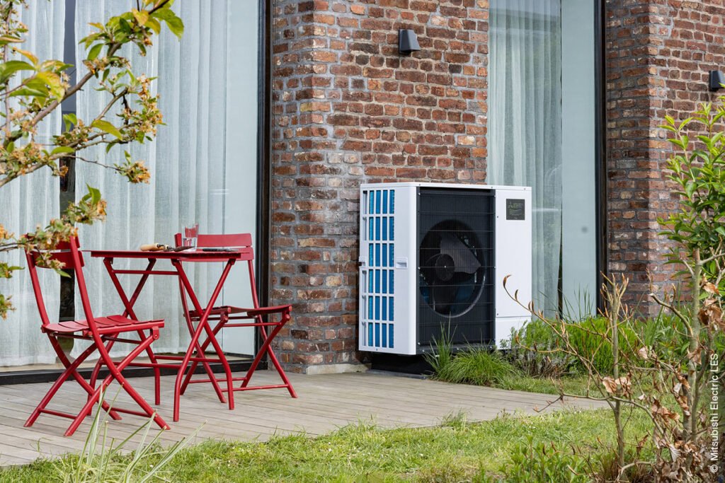 Terrasse mit roten Stühlen und Wärmepumpe von Mitsubishi