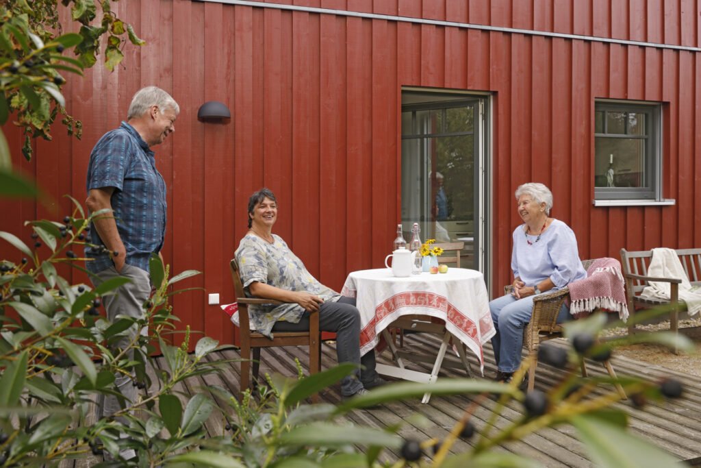 Die Bauherren mit Mutter auf der Terrasse vor dem Haus.