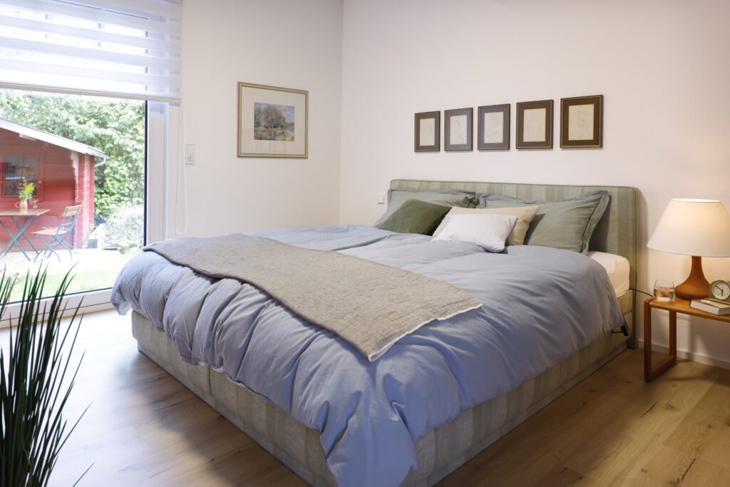 Auch das Schlafzimmer verfügt über ein bodentiefes Fenster bzw. Glastür. 